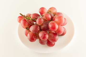bunch of fresh grapes lies on a dinner plate