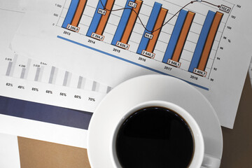 there are documents on the desktop that show a color chart. A white Cup of coffee next to the...
