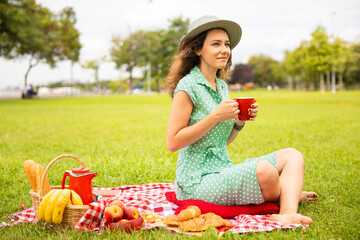 Beautiful young woman having picnic.