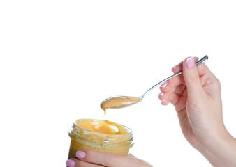 Jar with teaspoon peanut paste in hand on white background isolation