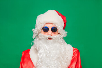 newyear atmosphere presents, wear red santa costume sunglass headwear. isolated green color background