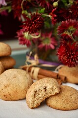 Cinnamon cookies on the table with dark red flowers