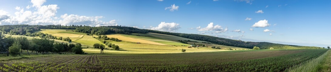 Fototapeta na wymiar Idyllic panorama from farmland and meadows