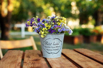 Bouquet of summer flowers in vase on table on terrace. Fresh Field flowers in vase. Cozy home decor...
