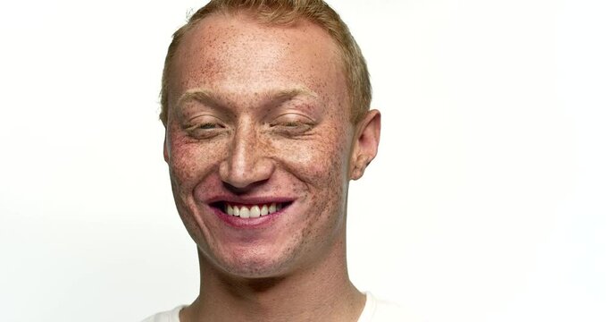 Camera pushes in on a redhead boy as he smiles.