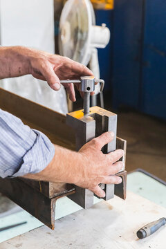 Worker In A Factory Holds Squeezes Two Metal Beams By The Vice