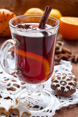 Hot red mulled wine with christmas spices and cookies, orange, anise and cinnamon sticks