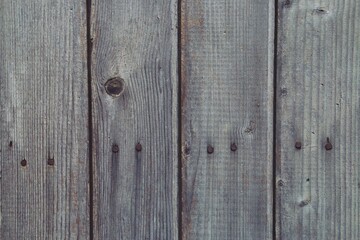 Naklejka premium Viejas y toscas tablas de madera de una valla. Fondo rústico de tablones de madera envejecidas por su exposición al exterior.