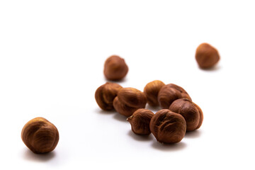 Fototapeta premium Lots of hazelnuts scattered on white isolated background macro photo