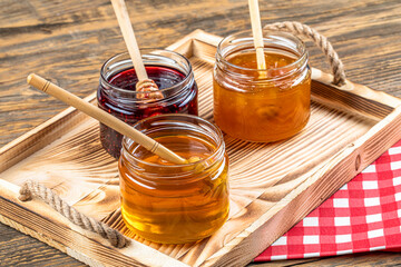 Various fruit marmalade jams in jars top view. Honey, apricot jam and strawberry jam in jars