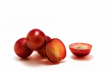 Red grapes and its half on white isolated background macro photo