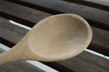 Wooden spoon on a table with several boards.