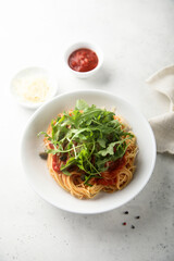 Pasta with tomato sauce, capers and arugula