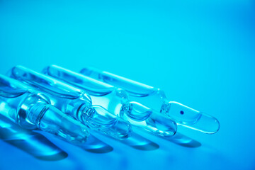 glass ampoules with liquid medicine in blue light