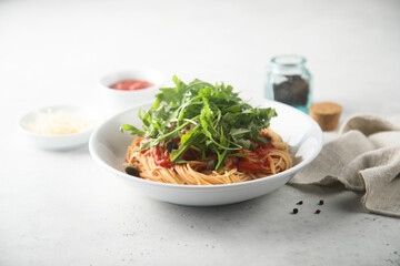 Pasta with tomato sauce, capers and arugula