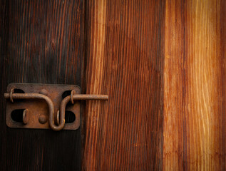 old rusty metal latch on a weathered farm shed wooden door