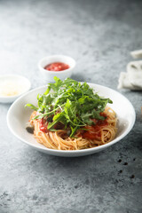 Pasta with tomato sauce, capers and arugula