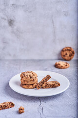cookies with chocolate shavings on top of a plate on a stone background.