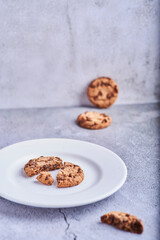 cookies with chocolate shavings on top of a plate on a stone background.