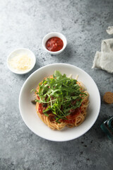 Pasta with tomato sauce, capers and arugula