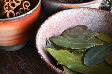 A close up image of dried bay leaves in a hand made pottery bowl. 