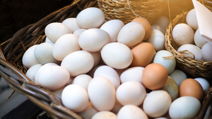 Group of fresh white and brown eggs in basket at the farm