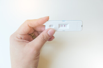 A woman's hand shows the results of a hormonal analysis of urine for ็็HCG, Pregnancy quick test isolated white background