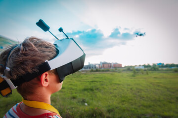 boy flying drone in virtual reality glasses in nature