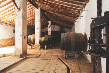 Wine barrels stacked in the old cellar of the vinery in Spain
