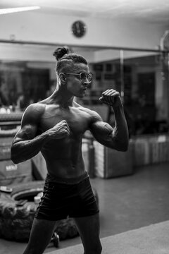 Young shredded and fit boy working out in the gym,standing in a boxing pose.