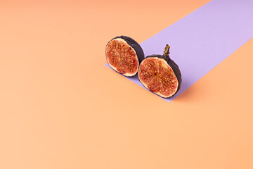 Creative layout made with figs and paper artificial shadow on orange background. Minimal food...