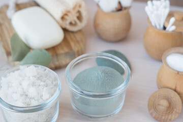 Beauty and fashion concept with spa setting. composition with Dead sea salt, coconut,  natural cosmetic blue clay, loofah. Flat lay, Spa concept with flowers, stones and towel.