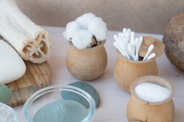 Obraz na płótnie Canvas Beauty and fashion concept with spa setting. composition with Dead sea salt, coconut, natural cosmetic blue clay, soda, loofah. Flat lay, Spa concept with cotton flower, stones and towel.