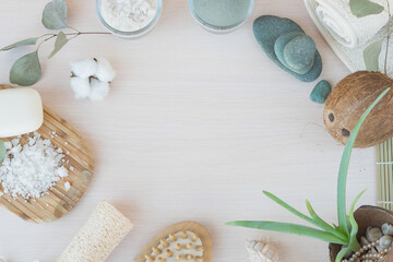Fototapeta na wymiar Beauty and fashion concept with spa setting. composition with Dead sea salt, coconut, natural cosmetic blue clay, soda, loofah. Flat lay, Spa concept with cotton flower, stones and towel.