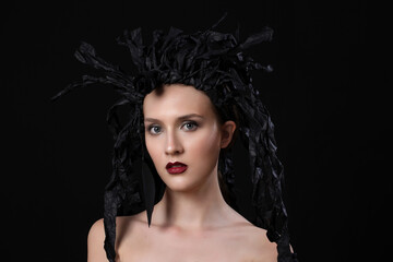 Creative art fashion look, young model whit black paper wardrobe, isolated on black