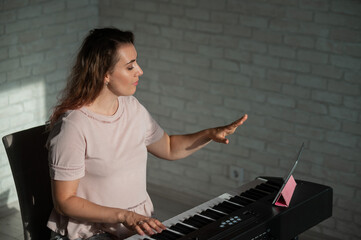 Naklejka na ściany i meble Female singing teacher at online lesson on digital tablet