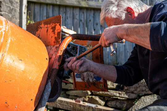 Senior Male fixing cerment mixer belt by setting tension of belt to prevent from slipping