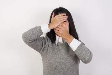 Young  businesswoman with retro short hair wearing casual clothes standing over isolated white background  Covering eyes and mouth with hands, surprised and shocked. Hiding emotions.