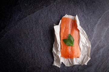 Fresh salmon filet and spices on a concrete black background. Ingredients for cooking.