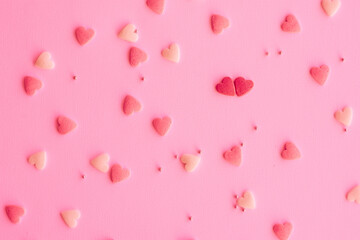 Candies hearts on pink and white paper. Flat lay for Valentine’s Day. Creative sweet concept. Background, top view