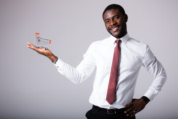 Shopping basket in hand of african american businessman on white background