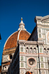 Close up. The white marble facade (exterior) of the central church (Duomo), also known as Santa Maria del Fiore Cathedral, with the tower and the Renaissance dome in Florence, Tuscany, Italy. Europe