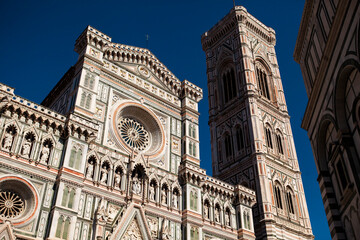 Fototapeta premium The white marble facade (exterior) of the central church (Duomo), also known as Santa Maria del Fiore Cathedral, with the tower and the Renaissance orange dome in Florence, Tuscany, Italy. Europe