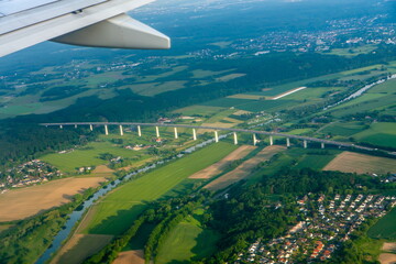 Wing, village and bridge over the river top view from the plane