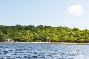 Lago deserto com agua azul e margem com mata nativa.