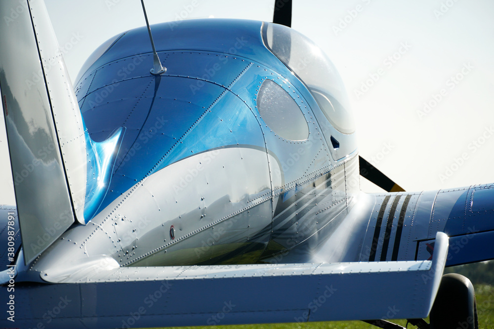 Canvas Prints Closeup of a blue single-engine aircraft in a field during daylight