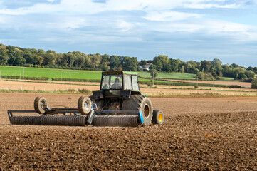 Tractor cultivating field at spring