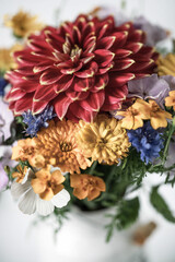 a bouquet of autumn flowers with a red Dahlia in a ceramic pot in a vintage style