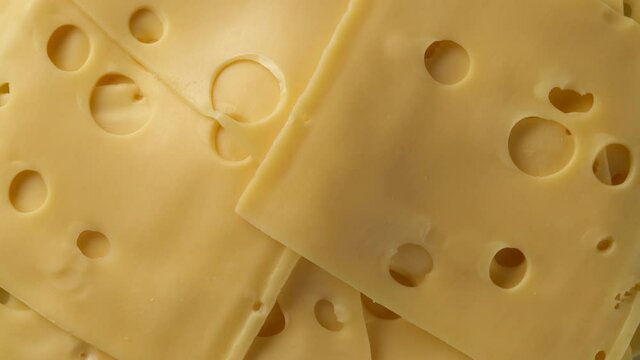 cheese with holes top view rotating. gold Netherlands or Swiss cheese