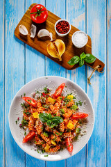 Fusilli with tomato sauce, meat and parmesan on wooden table
